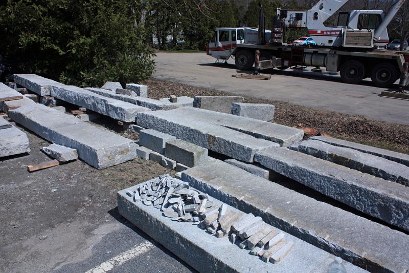 Granite slabs, being leveled by hand by Ron Hawkins, will eventually sit atop a new concrete foundation, with the historic barn that dates back 200 years or more on top of that. The barn will serve as an auxilliary building for Mahogany Salon at 63 Elm. St. (Photo by Holly S. Edwards)