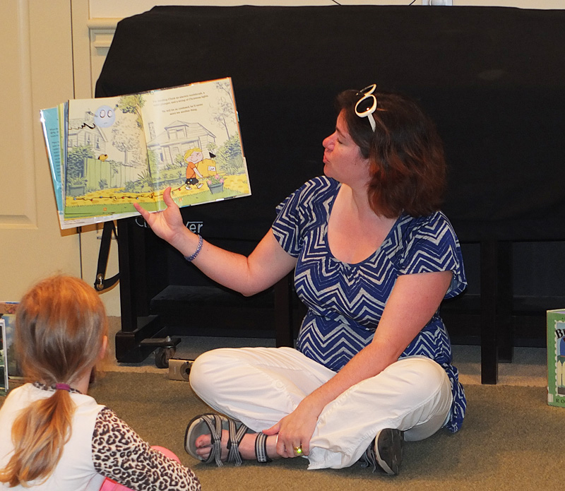 Stephanie McAllister, assistant children’s librarian, reads to children at the library’s story hour Saturday morning.