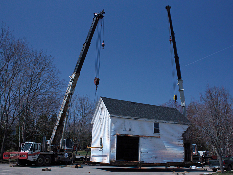 The barn behind 59 Elm St., a house owned by the First Congregational Church of Camden that has served as a residence for Coastal Opportunities tenants for 25 years, is lifted from its foundation Monday morning and moved next door to 63 Elm St., a parcel owned by Denise Pukas. (Photo by Holly S. Edwards)