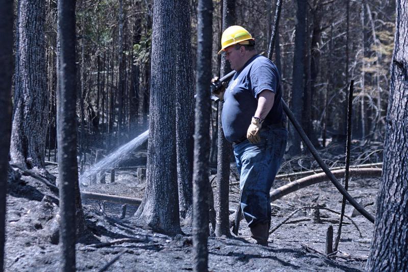Firefighters from Liberty, Montville and Morrill joined Searsmont early Thursday evening to battle a woods fire off Choate and Jackson roads in Searsmont, while 56 volunteers from more towns across Knox and Waldo counties joined the continued effort Friday. Pictured is Hank Lang of Northport and Lincolnville fire departments. (Photo by Holly S. Edwards)