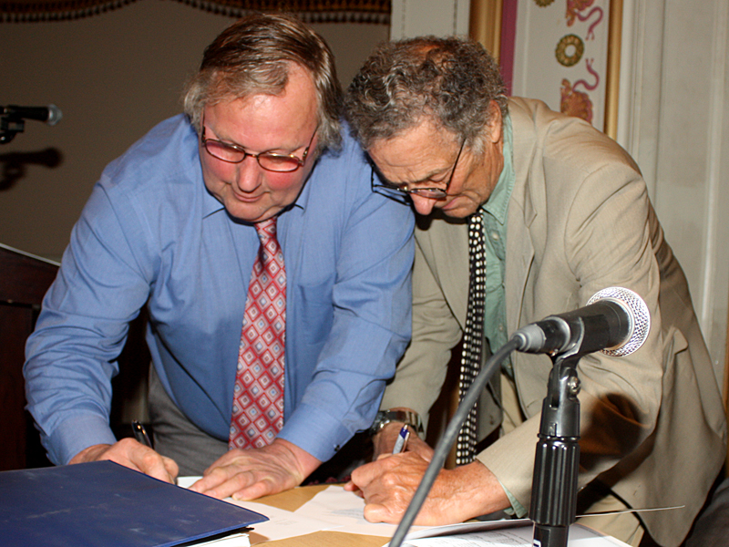 From left, John French and Leonard Lookner sign paperwork that officially puts them on the Camden Select Board for another three years. Both incumbents, French won back his seat with 356 votes and Lookner with 314. French was also selected by fellow board members to serve as chairman for the next year. (Photo by Holly S. Edwards)