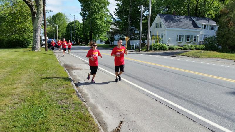 Jeff Boudreau, Camden Police officer, leads the runners with the torch along with Jala Tooley. Photo by Sarah Shepherd