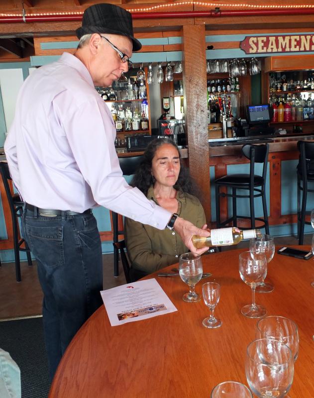 Sommelier Mark Guerin pours wine for dinner guest Sue Mello. SUZI THAYER/Boothbay Register