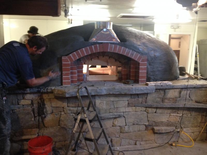 The wood-burning oven, made of granite and clay, is constructed by the community, and is a signature part of every Flatbread Company restaurant. (Photo courtesy Allen Mitchell)