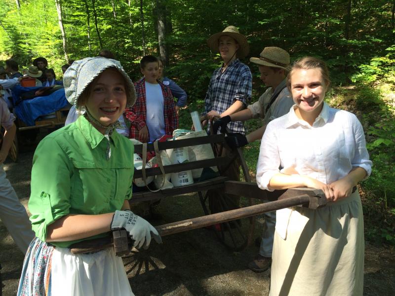 Eliza Crowley and Courtney Harrington pull a loaded handcart through the Camden Hills. (Photo credit: Jeff Thomas)