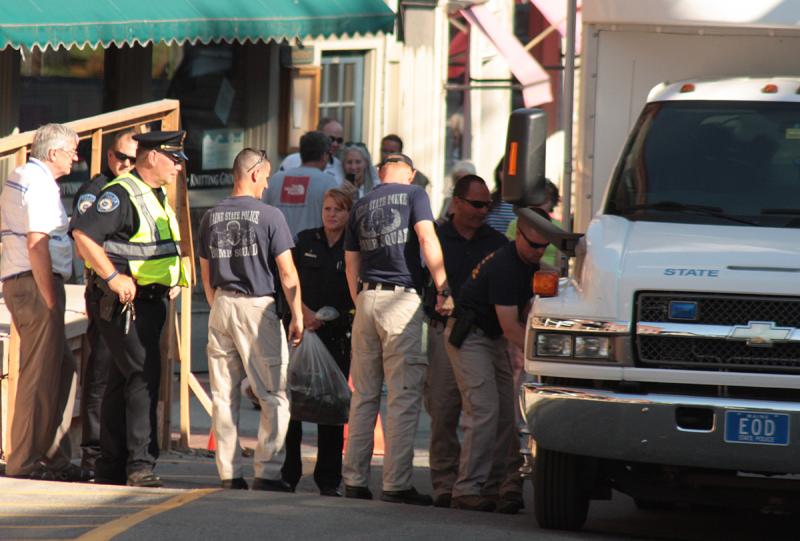 The remains of the detonated backpack, bagged up by the State Police Bomb Squad, is delivered to Camden police officers. (Photo by Holly S. Edwards)