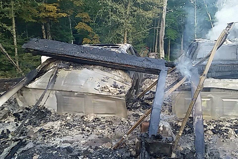 The metal frames of two vehicles are covered by rubble after the fire. (Courtesy photo)