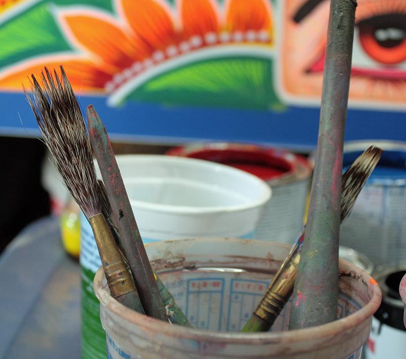 Eschewing American paint brushes, Haider Ali uses his own, made of mongoose hair. (Photo by Holly S. Edwards)