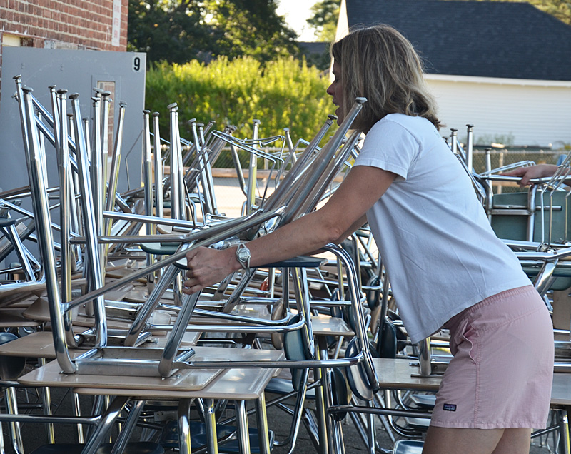 Kristen Nelson adds another desk to the growing stack. They estimated between 80 and 100 desks would go to Haiti.