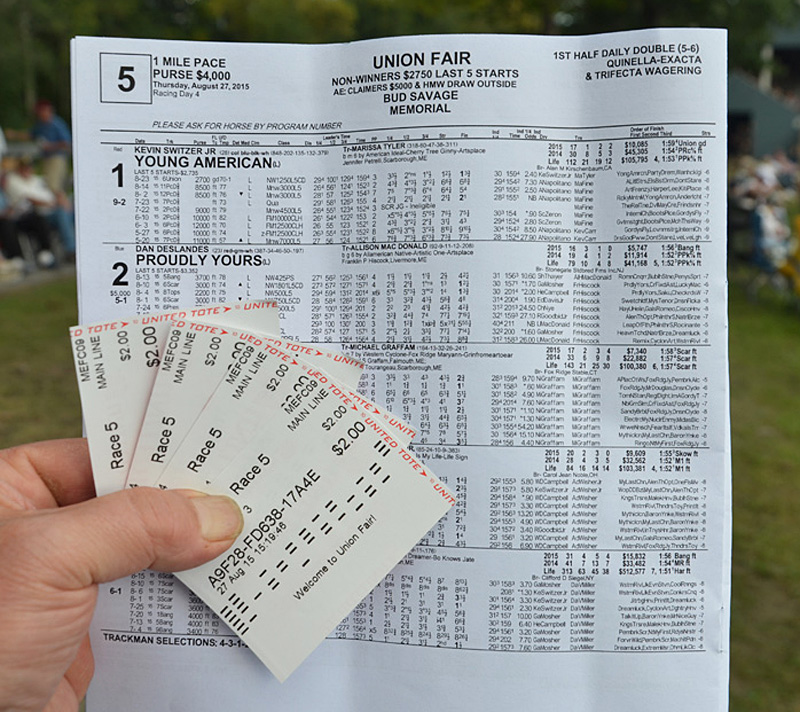 A racing form with tickets showing horses to win, place and show.
