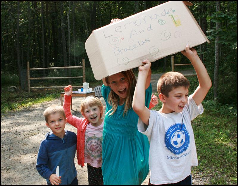 Parker Olson, Faye Hildreth, Anna Hildreth and Ellory Olson shout and try to get the attention of passing automobiles to stop for some lemonade. (Photos by Chris Wolf))