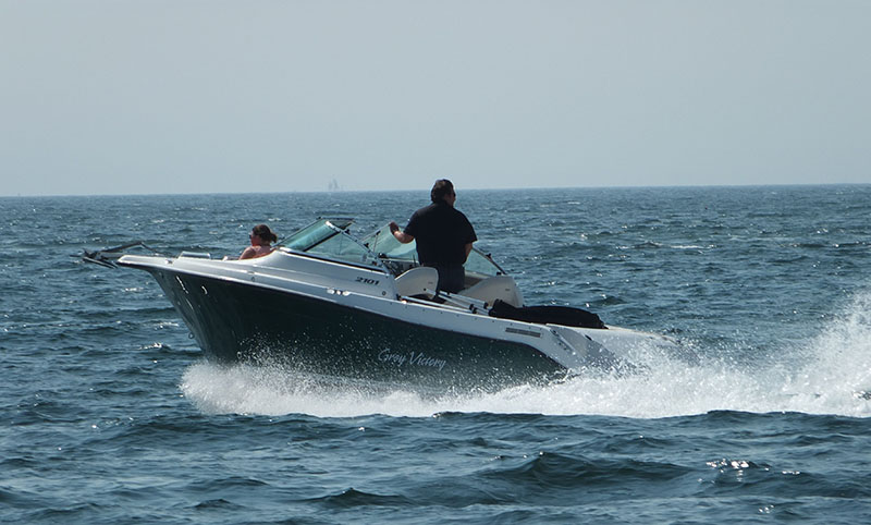 A pleasure boat under full power takes to the bay.