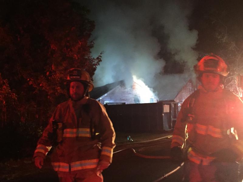 Firefighters walk down West Alna Road in Alna as work continues on putting out a house fire. SUSAN JOHNS/Wiscasset Newspaper