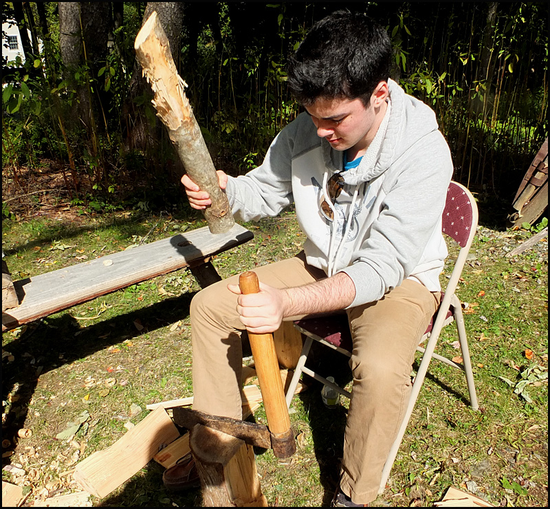 Tyler Bilodeau shows a froe in action, splitting shingles from a quartered log.
