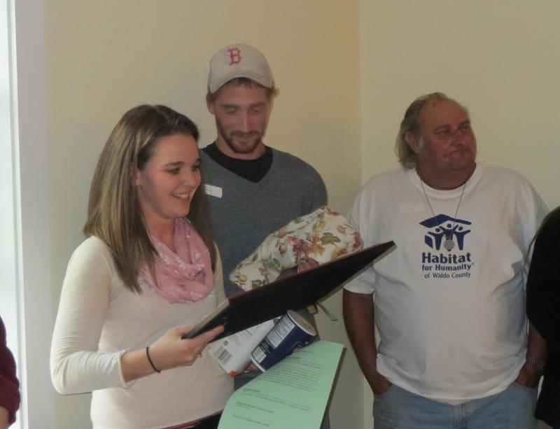 Bilzier and Thibodeau receive a painting as a gift for their new home. (photo by Erica Thoms)