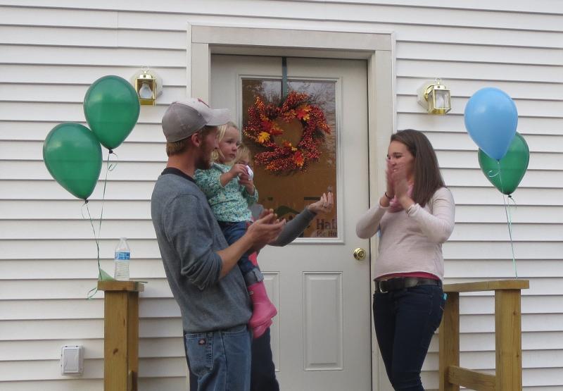 The family celebrate after cutting the ribbon on their new front door. (photo by Erica Thoms)