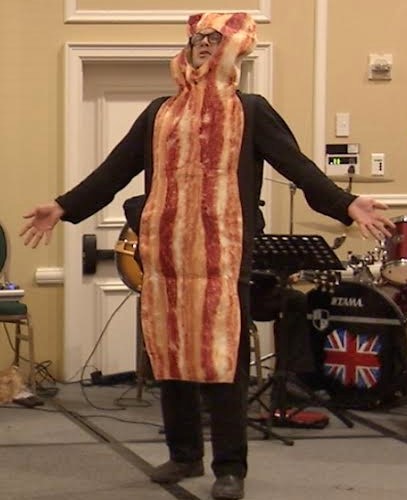 Andy O’Brien, managing editor of the Free Press, sings and laments the “bad rap” that bacon gets in The After Hours Kitchen Cabaret, a skit presented at the kickoff for the MCH-Meals On Wheels Kitchen Appeal campaign. This campaign is raising funds to support an MCH kitchen expansion to feed more seniors and people with special needs in the years ahead.