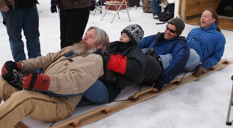 Mike on the back of the toboggan, with his team, practicing their racing form.