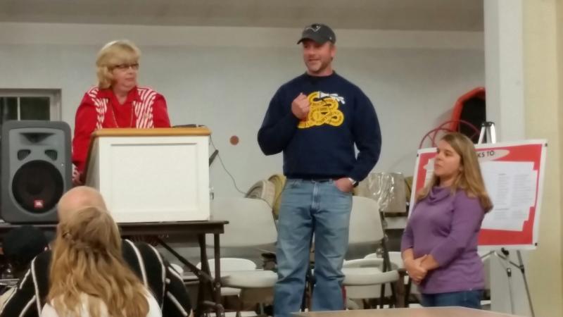 David Leighton, with his wife Lisa, addresses the room full of supporters at his benefit dinner, held in October. Linda Payson, left, lead the crowd in the live auction. (Photo by Sarah Shepherd)