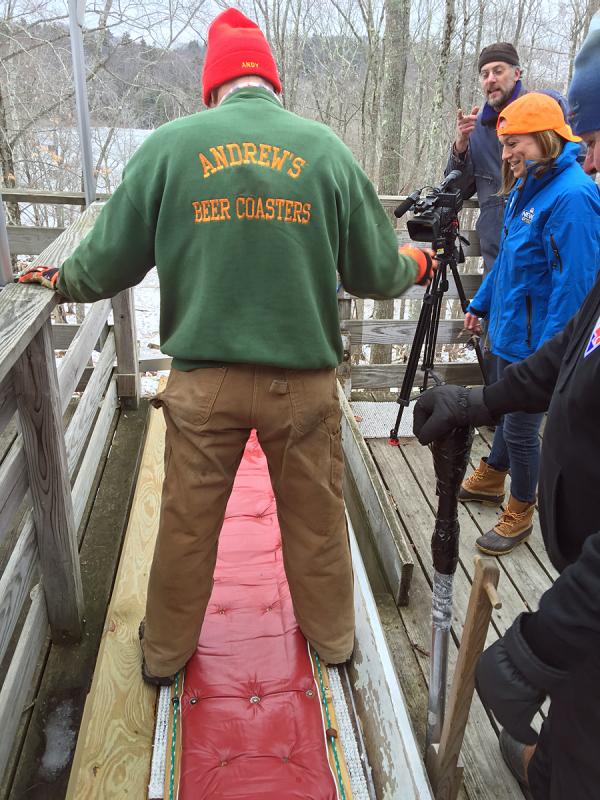 Veteran toboggan racer Andy Hazen gives WLBZ 2 sports reporter Jessica Gagne some tips before they load onto the sled for a run down onto Hosmer Pond. (Photo by Holly S. Edwards)