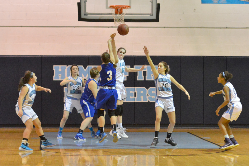 Oceanside’s Elise Laslavic, back center, tells Morse’s Maddy Mitchell not in my house as she swats the ball away on the shot. (Photo by Ron Hawkes)