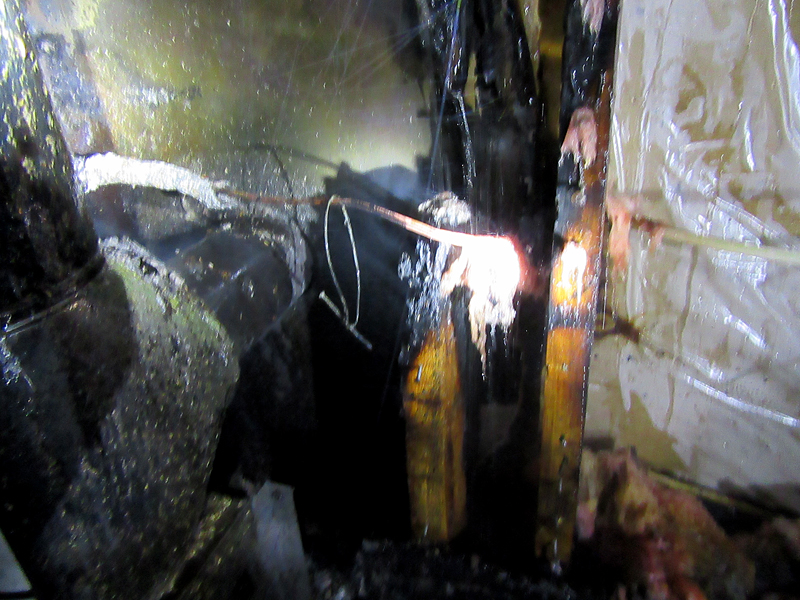 Wiring for an electrical switch, and the bit of wire and a nail used to hold it up above the stove pipe, actually acted as a heat conductor to exacerbate the problem that caused the wall to catch fire. (Courtesy Rockport Fire Department)