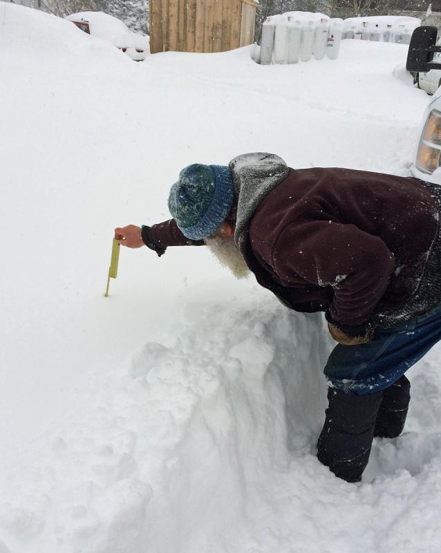 Paul Murray measures the snow on Matinicus: 2 feet so far. (Photo by Eva Murray)