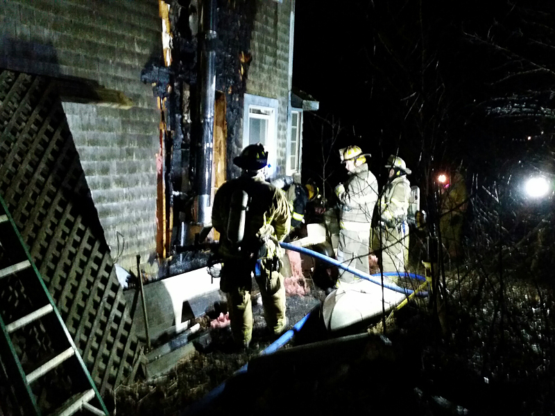 Fire heavily damaged the side of the home at 30 Winding Way in Rockport Saturday night, while Rockport firefighters worked to put it out with help from Camden, Rockland and Hope fire departments. (Photo by Sarah Shepherd)