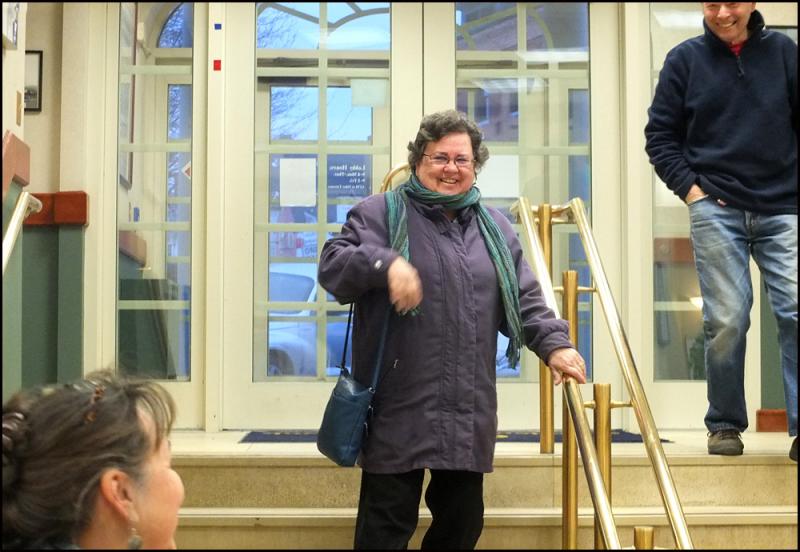 Donna Perry comes down the steps into the Camden National Bank lobby after realizing the crowd of people are there for her. (Photos by Chris Wolf)