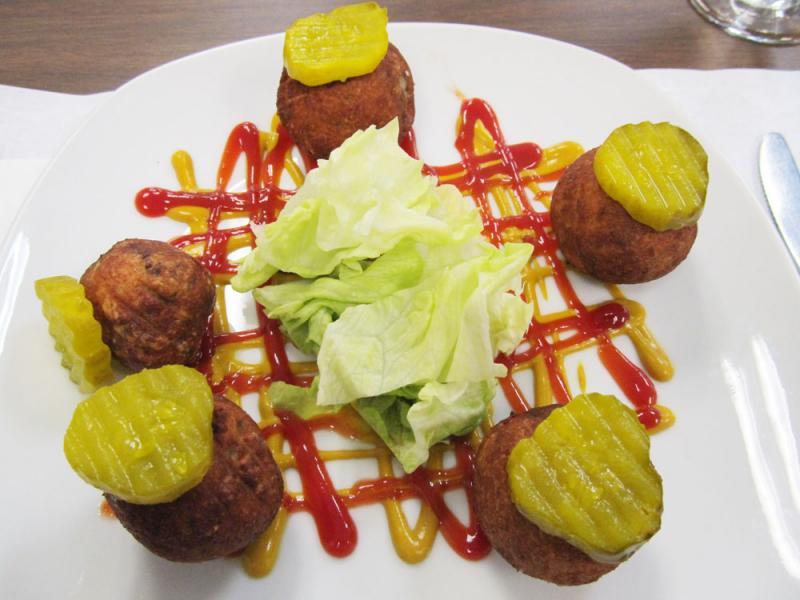 Fried cheeseburger balls with drizzles of ketchup and mustard, a $3 deal on the World Cafe’s American menu. (Photo by Kay Stephens)