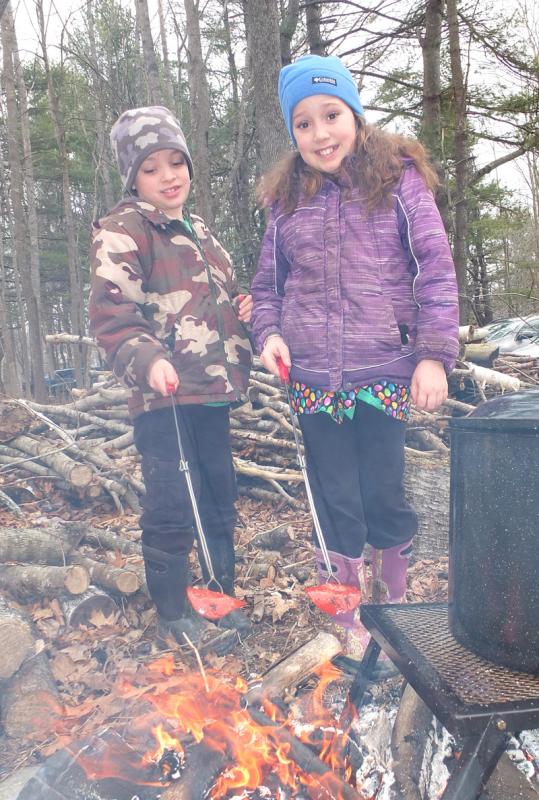 Peter and Hope Monro of Owls Head enjoy the pleasures of maple flavored pepperoni cooked over an open fire. (Photo by Chris Wolf)