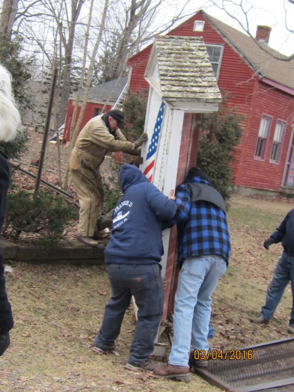 Lifting the Honor Roll off its resting place.
Photo by Diane O’Brien honor roll