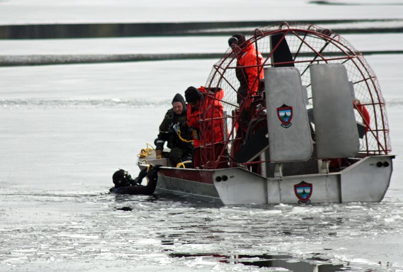 A Maine Warden Service diver slips into Megunticook Lake, about 150-feet off Wiley Neck in Lincolnville, Tuesday morning to search for the body of 20-year-old Trueman Moore of Camden. (Photo by Holly Edwards)