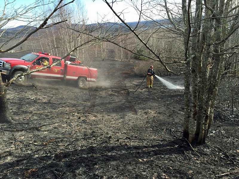 Hope firefighters use portable water tanks to contain and extinguish a woods fire on Sexton Avenue Sunday afternoon. (Courtesy Justin Ford)