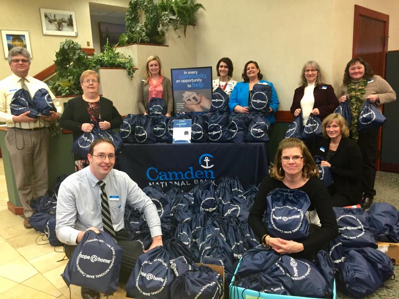 The Midcoast team with the completed kits (l-r), back row: Randy Cruz, Vickie Hersom, Jody Landrith, Nicole Hotchkin, Carissa Christie, Ann Brindle, Samantha Helander; front row, kneeling, (l-r), Jim Jarvis, Juanita Paparello and Crystal Spear.