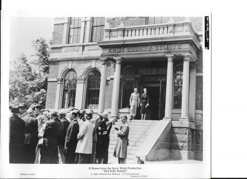A behind-the-scenes shot in ‘Peyton Place’ of Diane Varsi and Russ Tamblyn on the steps of Knox County Courthouse with extras (locals) in the foreground. (Courtesy Willard Carroll)