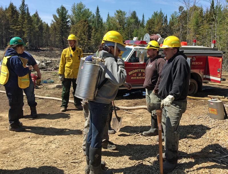 Battling a woods or grass fire most often requires carrying water in on foot via portable 5-gallon tanks. (Photo by Holly S. Edwards)