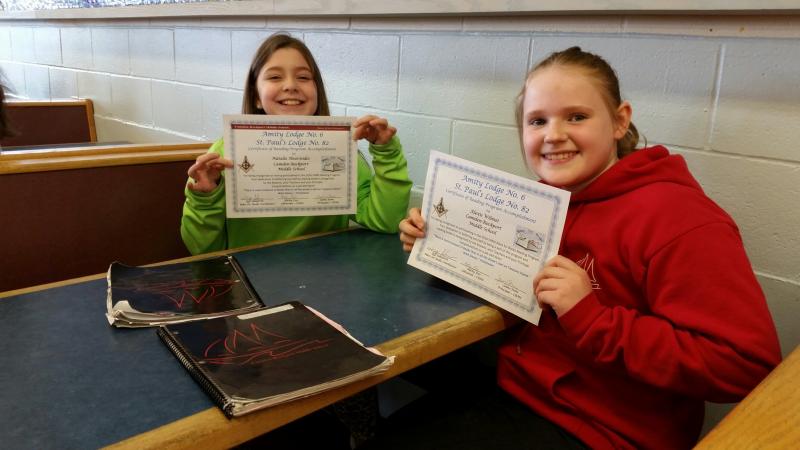 Students proudly display their certificates of achievement.