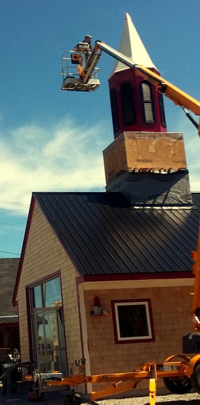 From the ground to the top of the building, a new steeple gets set into place.