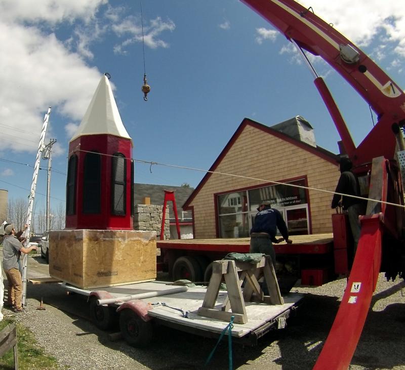 From the ground to the top of the building, a new steeple gets set into place.