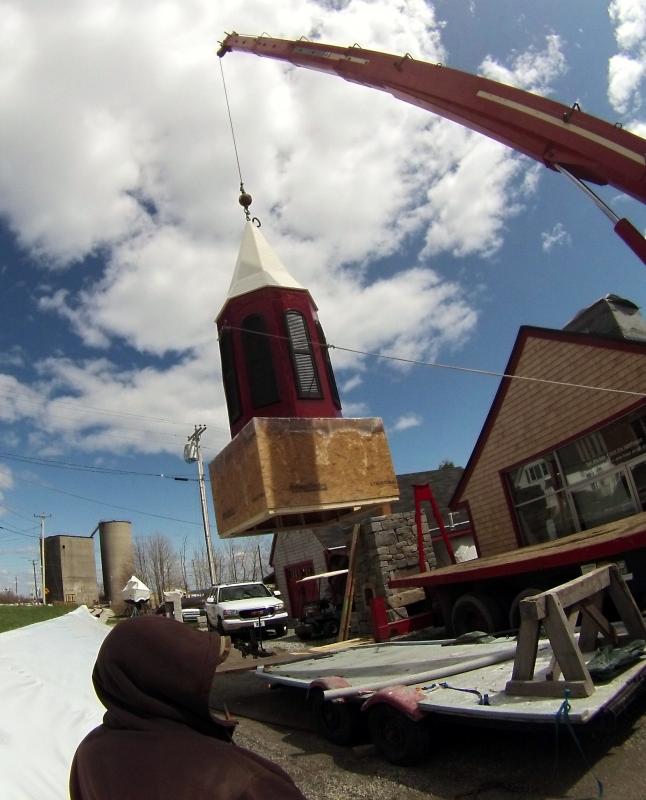From the ground to the top of the building, a new steeple gets set into place.