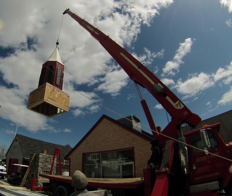 From the ground to the top of the building, a new steeple gets set into place.