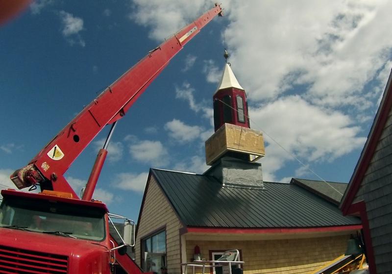 From the ground to the top of the building, a new steeple gets set into place.