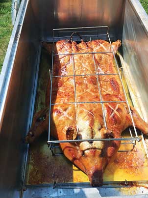 Maine Street Meats’ public pig roast in front of State of Maine Cheese building.