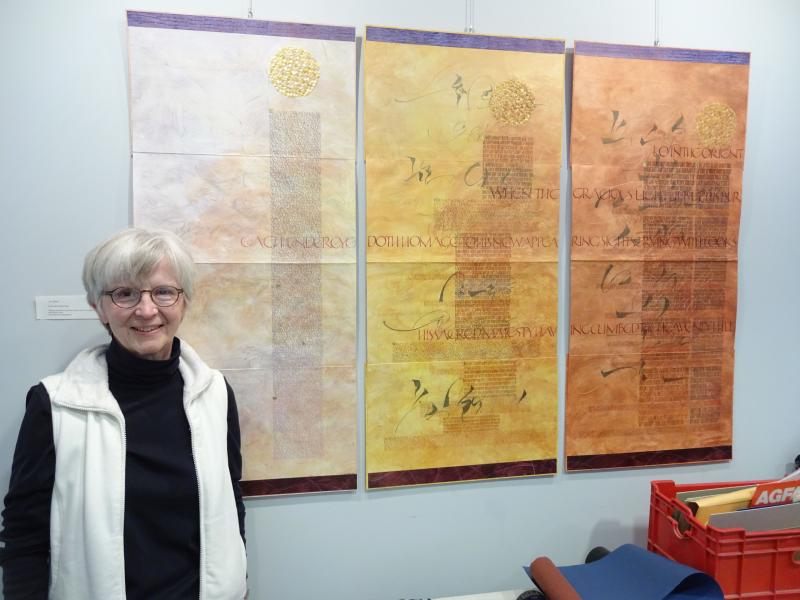 Book artist Jan Owen posing with several of her pieces, featured at the Belfast Library. (photo by Erica Thoms)