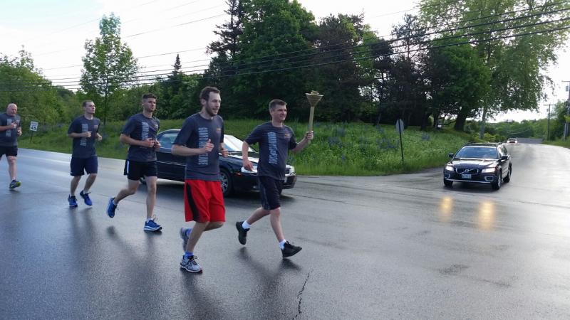 John Tooley, Camden Police officer, carries the torch with Jeff Baroody, Knox County Assistant District Attorney. (Photo by Sarah Shepherd)