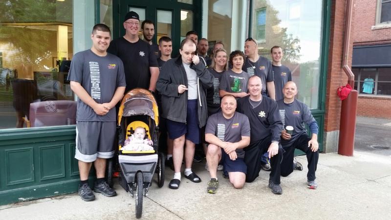 Graham Wiley (right of stroller), a Special Olympics athlete, gathers with the runners before they take to the streets for the annual Law Enforcement Torch Run. (Photo by Sarah Shepherd)