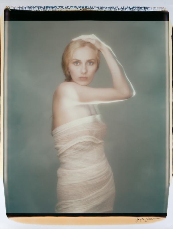 Suzanne with lit arm holding head. (Photo courtesy Joyce Tenneson)