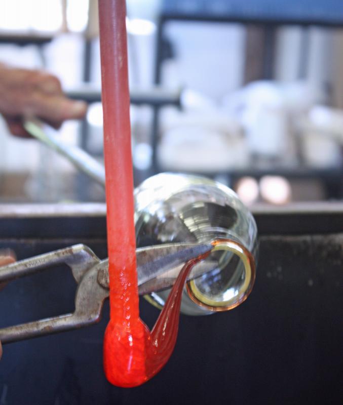 Using a pair of steel shears to cut molten glass. (Photo by Holly S. Edwards)