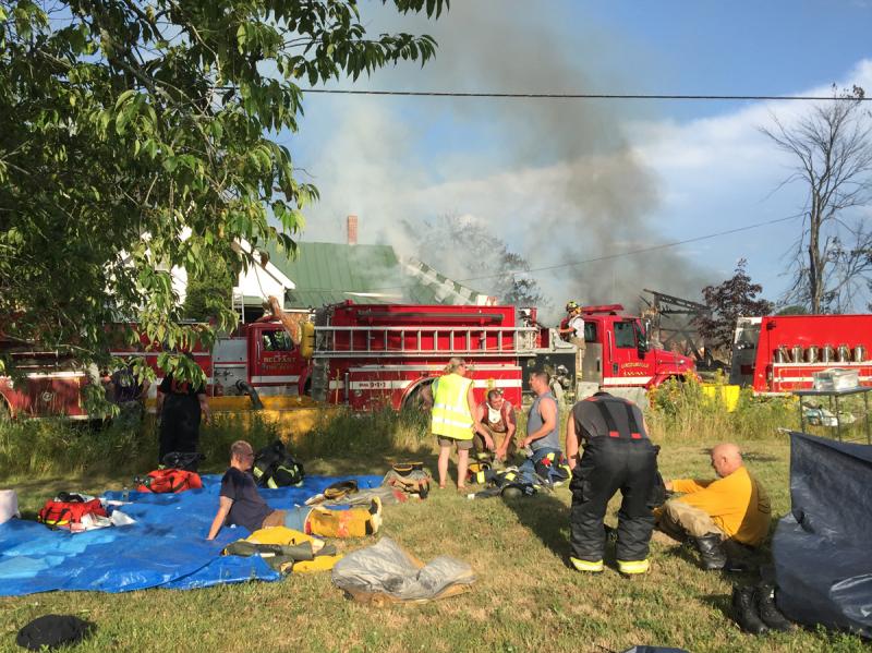 Hot and exhausted, firefighters sit out for “rehab” under the watchful eyes of ambulance crews and other volunteers, who made sure everybody on scene had plenty of water. (Photo by Holly S. Edwards)